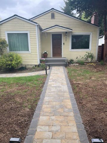 Front view of a beige house with a stone walkway leading to the front door
