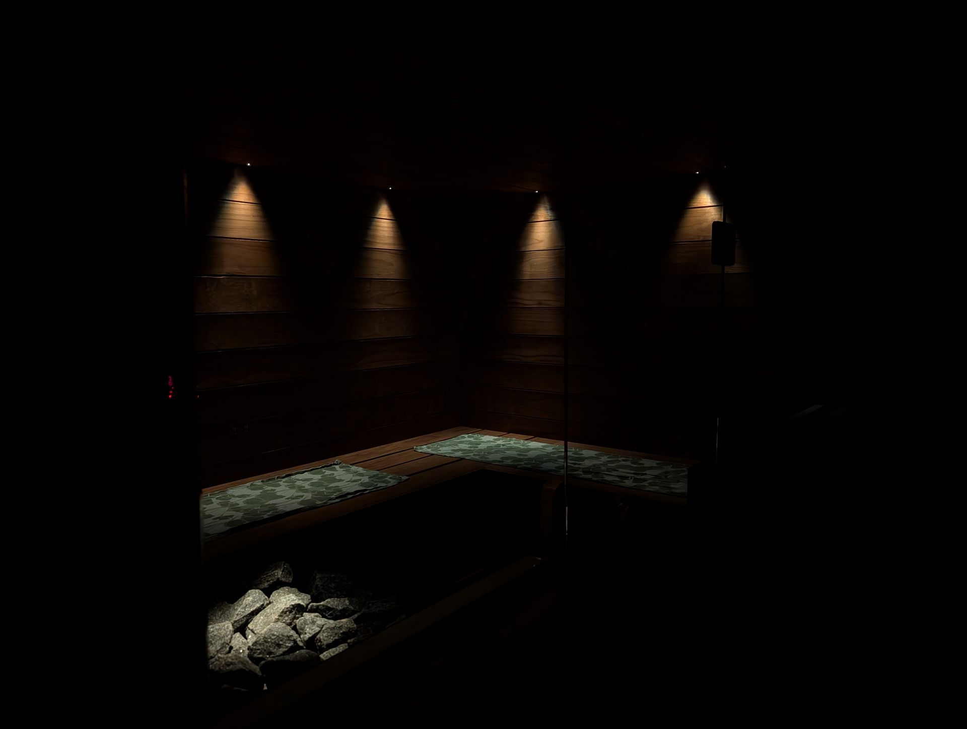 Dark room with four wall lights, a curved bench, and a pile of rocks in the lower left.