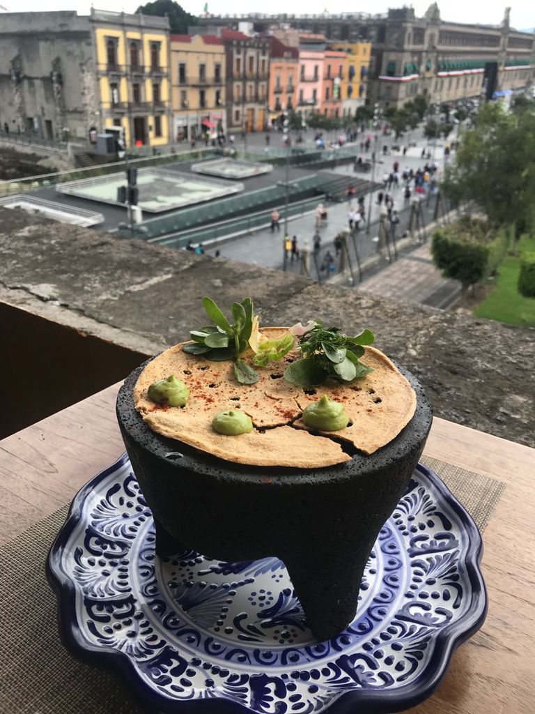Un plato de comida está encima de un plato azul y blanco sobre una mesa.