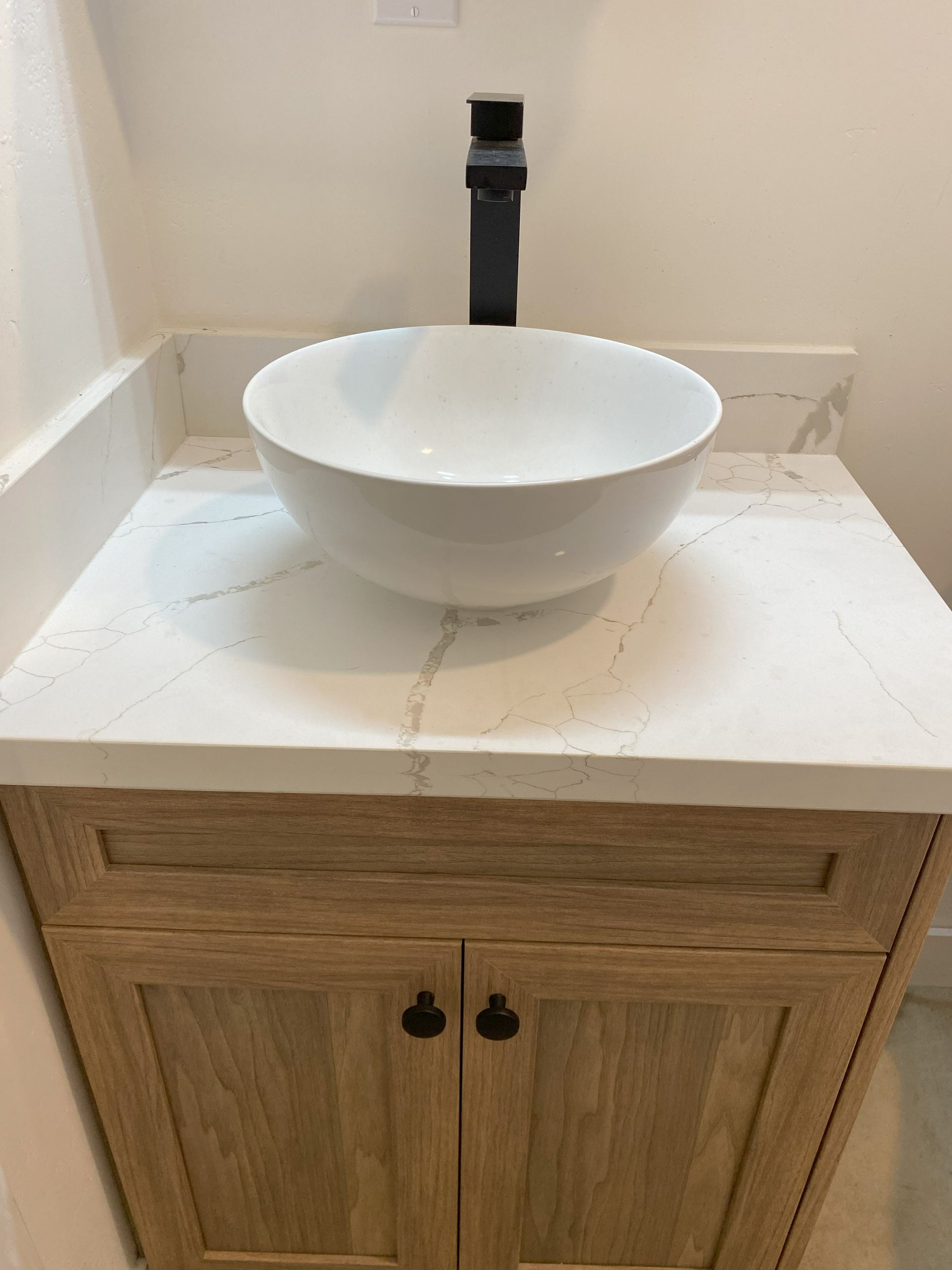 A bathroom sink is sitting on top of a wooden cabinet.