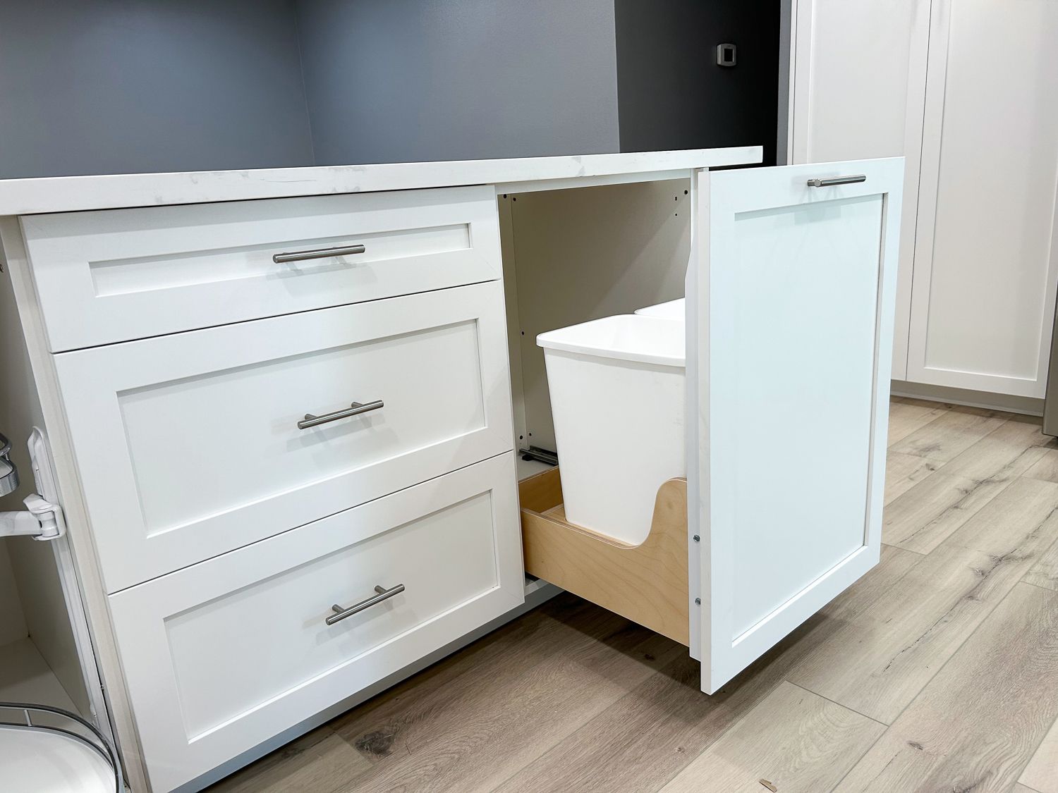 Hidden trash bins behind a beatiful cabinet drawer.