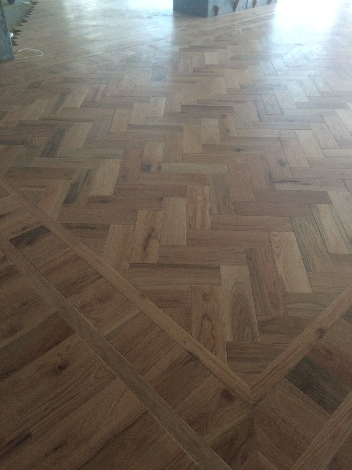 Parquet en bois à motif chevrons.