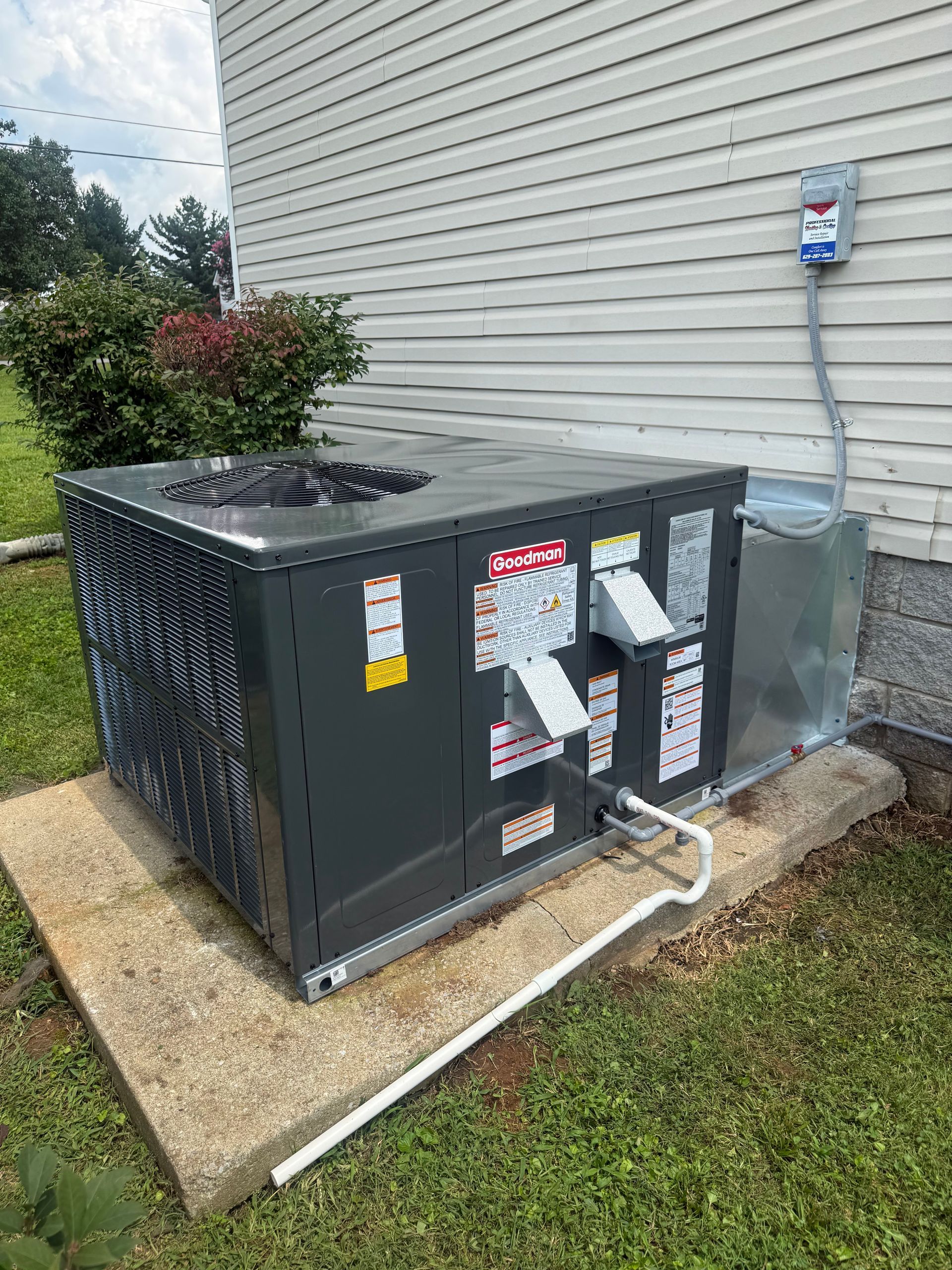Outdoor HVAC unit beside house with utility meter and conduit on concrete pad