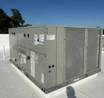 Large gray HVAC unit on a rooftop under a clear blue sky.