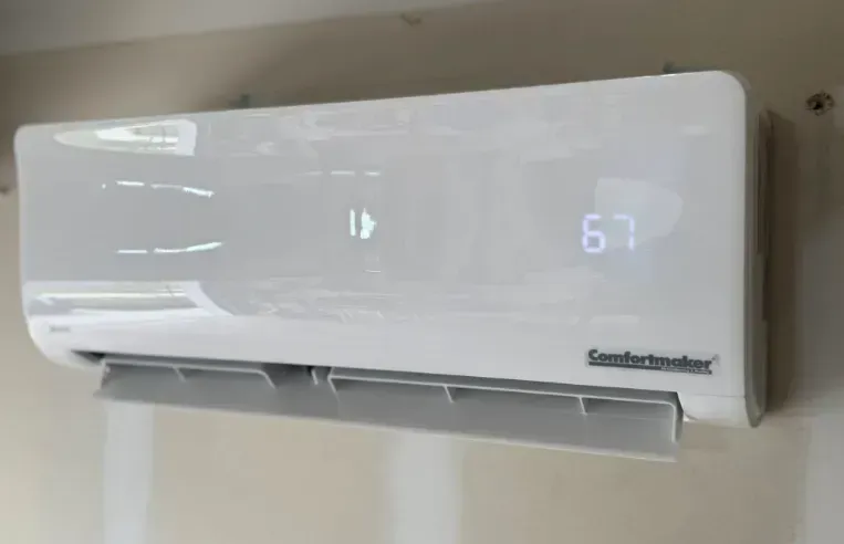 White wall-mounted air conditioner with a digital display showing 67°