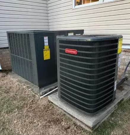 Two outdoor HVAC units beside a house, one gray and one black with a red Bryant logo.
