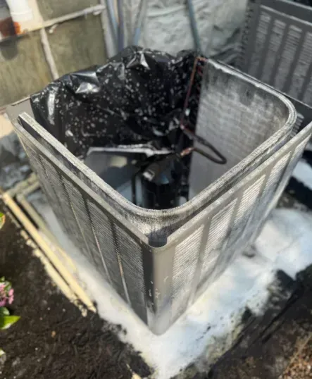 Black bin bag in a wire trash container on a snowy outdoor patio