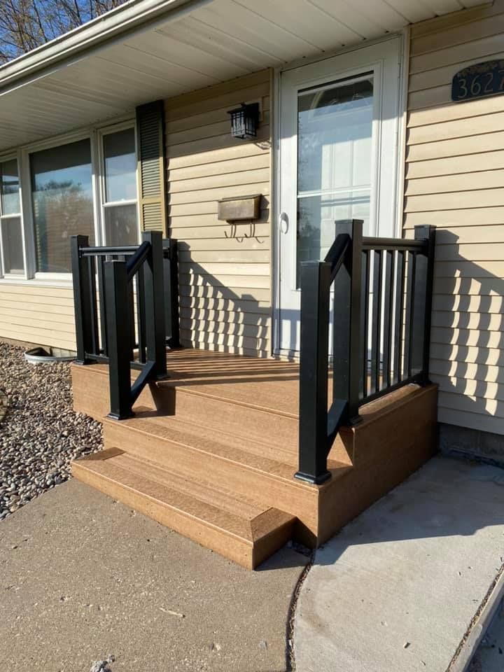 Wooden accessibility ramp and steps leading to a beige house entrance with black railings.