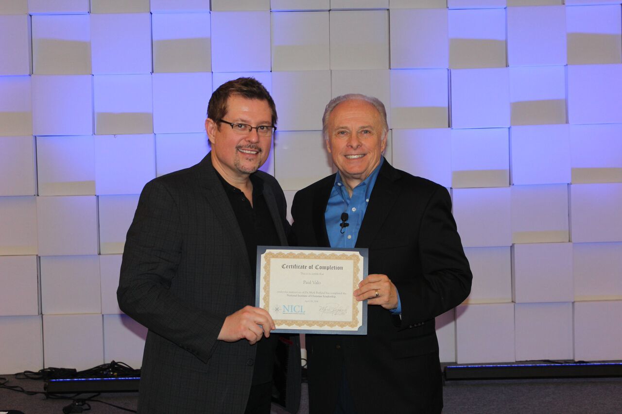 Two men standing next to each other holding a certificate