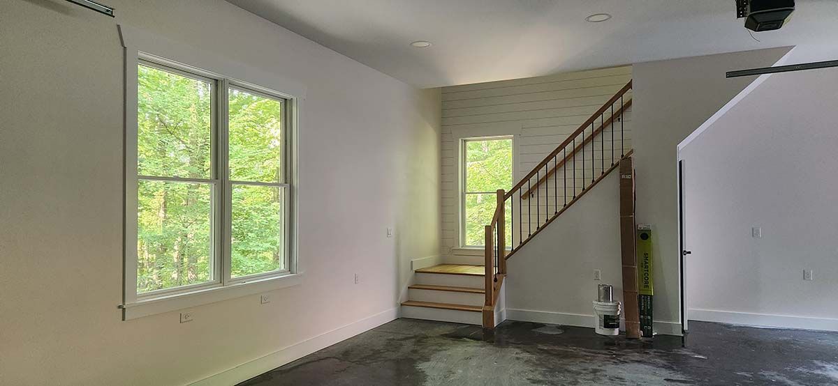 An empty living room with stairs leading up to the second floor.