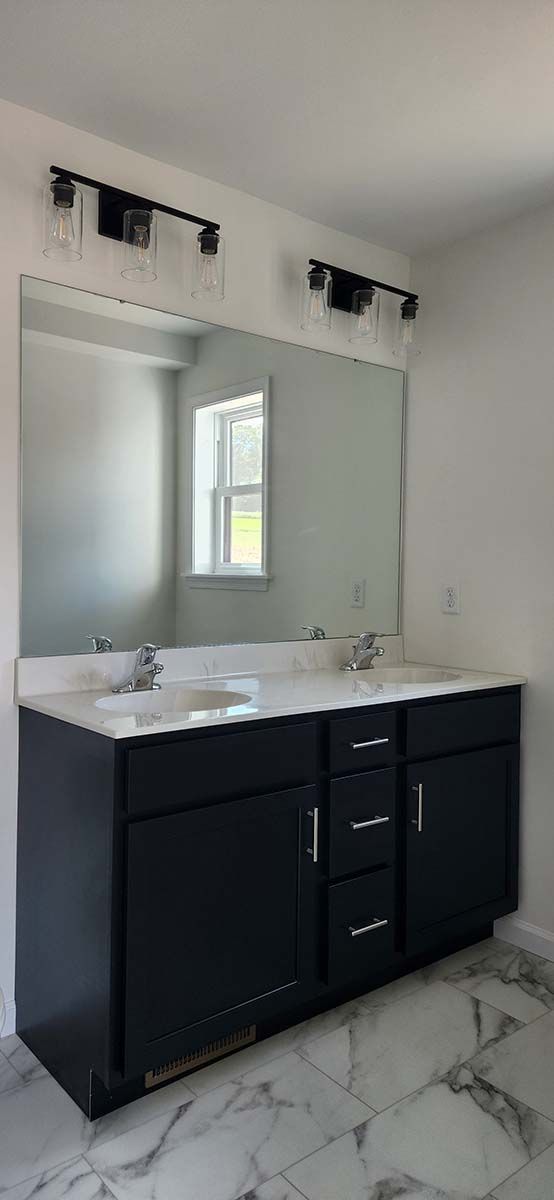 A bathroom with two sinks and a large mirror.