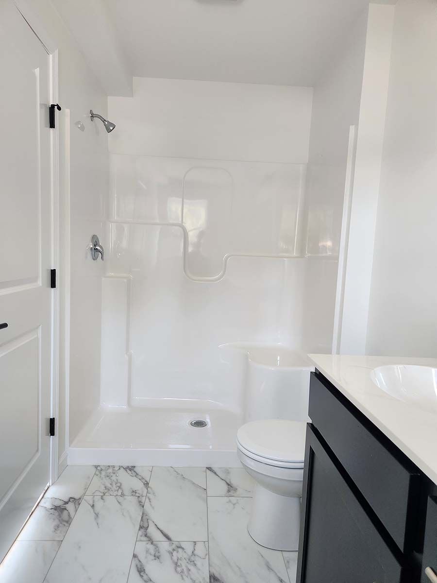 A bathroom with a toilet , sink , shower and bathtub.