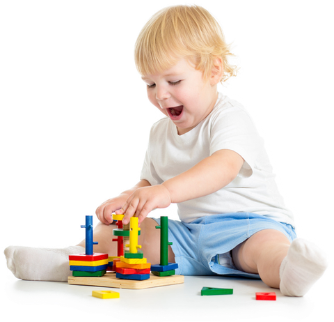 A little boy is sitting on the floor playing with colorful toys.