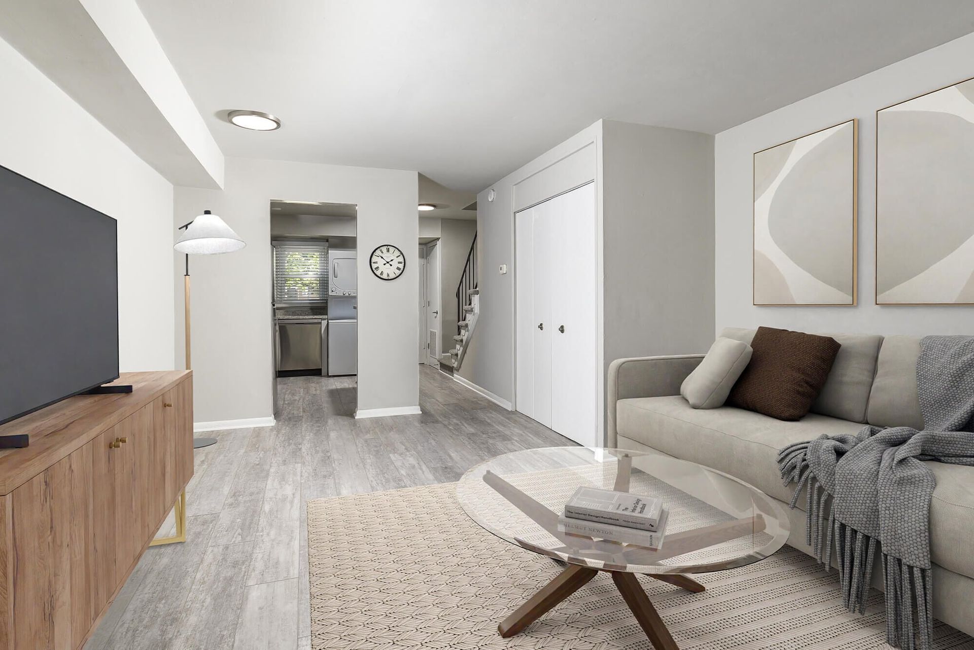 Open-concept living area with sofa, coffee table, TV, and visible kitchen.