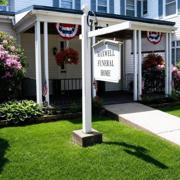 Front exterior of funeral home and cremations Beech Creek, PA with Maxwell Funeral Home porch sign