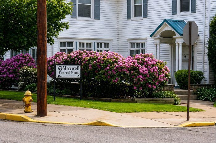 Street view of funeral home and cremations Renovo, PA with Maxwell Funeral Home sign and pink shrubs