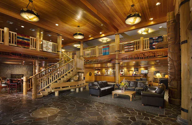 A large lobby of a hotel with a staircase leading up to the second floor.