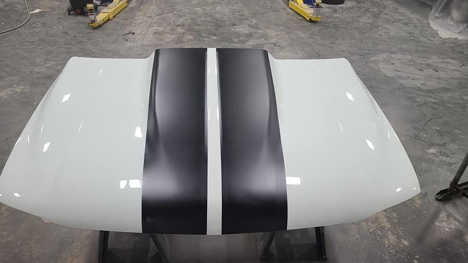A white hood with black stripes on it is sitting on a table.