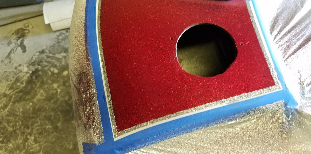 A red and gold object with a hole in the middle is sitting on a table.