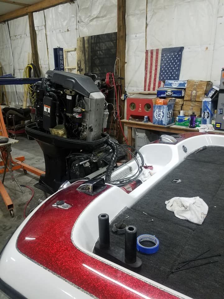 A boat with a motor is sitting in a garage.