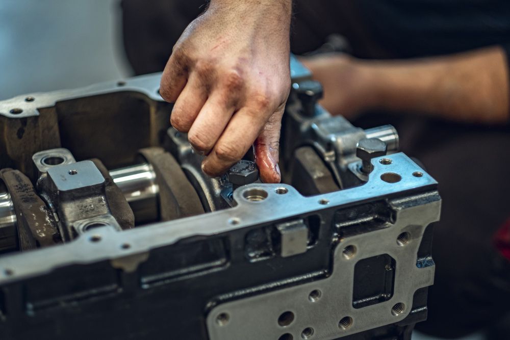 A Man Is Working On A Car Engine In A Garage — CAL AUTO Mobile Roadworthys in Bundaberg, QLD
