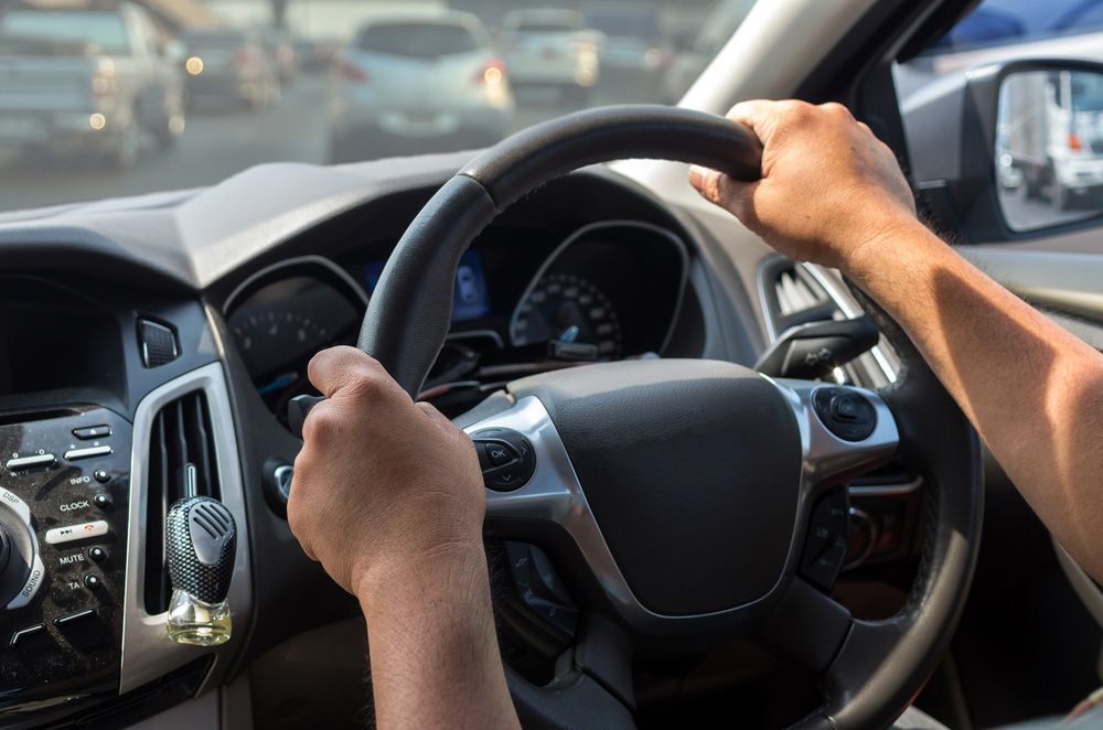 A Person Is Driving A Car With Their Hands On The Steering Wheel — CAL AUTO Mobile Roadworthys in Woodgate, QLD