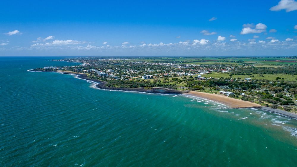 An Aerial View Of A Beach With A City In The Distance — CAL AUTO Mobile Roadworthys in Bargara, QLD