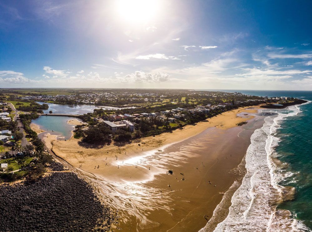 An Aerial View Of A Beach With Waves Crashing On The Shore — CAL AUTO Mobile Roadworthys in Bargara, QLD