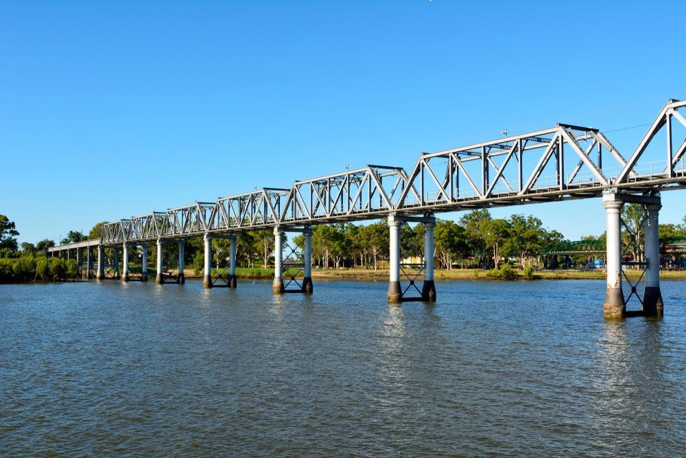 A Bridge Over A Body Of Water With Trees In The Background — CAL AUTO Mobile Roadworthys in Bundaberg, QLD