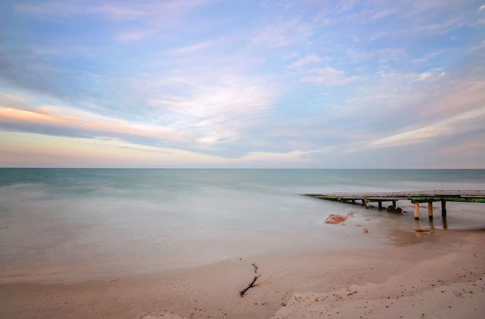 A Long Exposure Of A Beach With A Pier In The Distance — CAL AUTO Mobile Roadworthys in Woodgate, QLD
