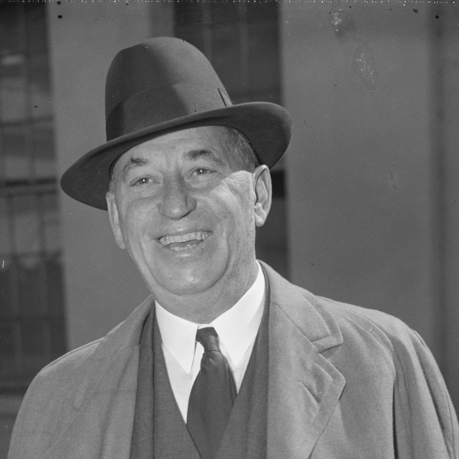A black and white photo of a man wearing a hat