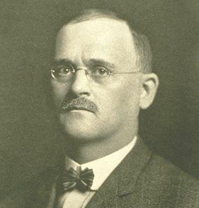 A man with glasses and a mustache is wearing a bow tie
