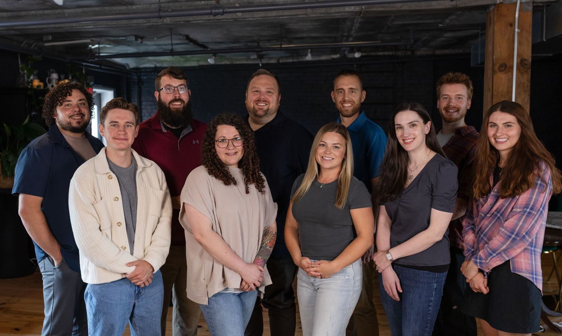 Group of diverse people smiling and posing indoors.
