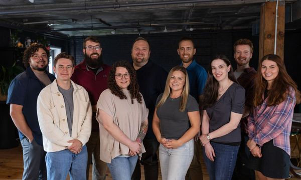 A group of people are posing for a picture together in a room.