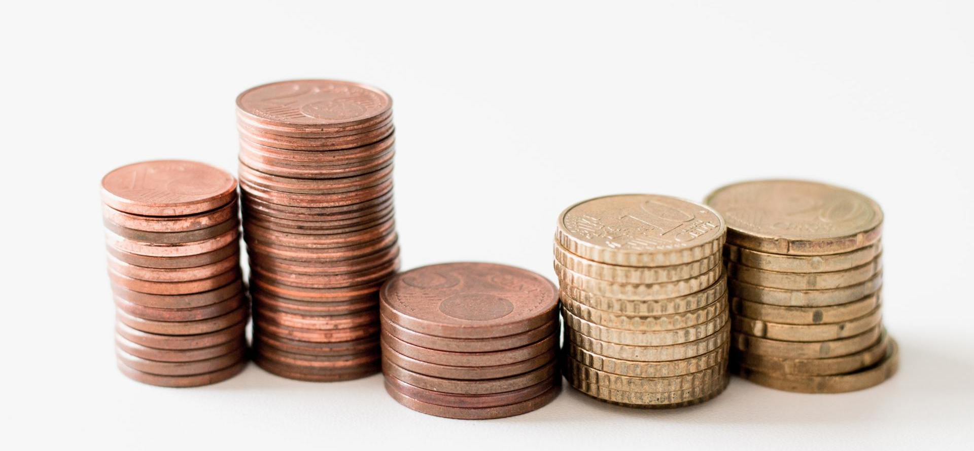 Three stacks of coins are stacked on top of each other on a white background.