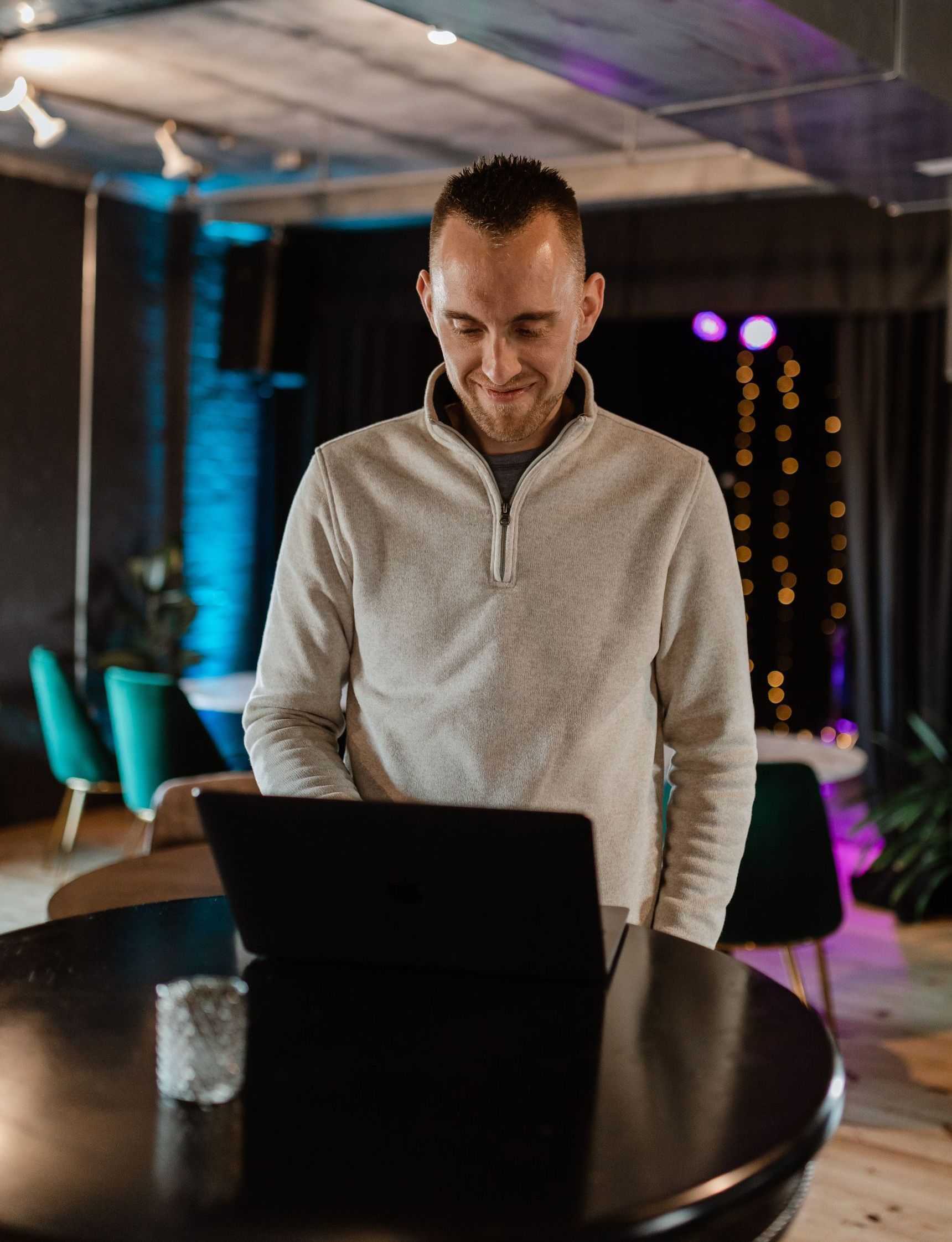 A man is standing in front of a laptop computer.