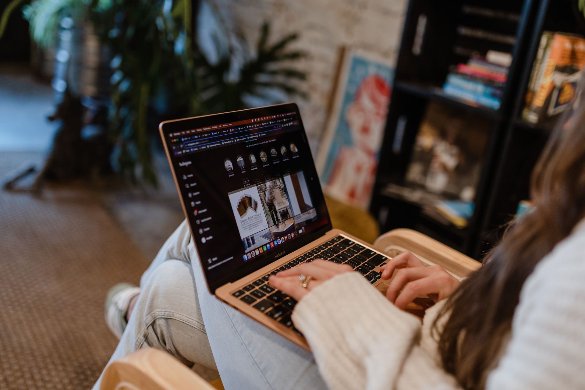 A woman is sitting in a chair using a laptop computer.