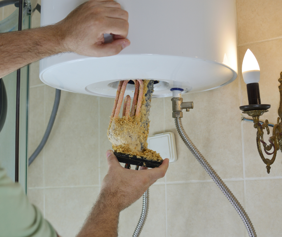 Hands removing a clogged bathroom sink drain with a mass of hair and debris hanging out underneath the basin