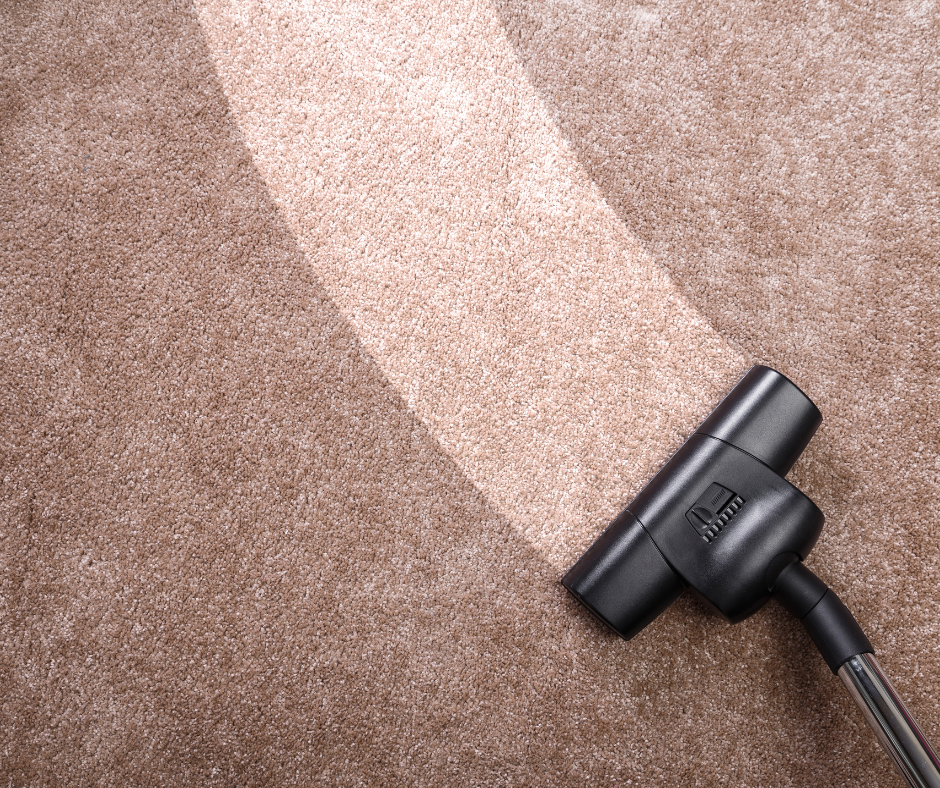 Vacuum nozzle cleaning a brown carpet with a light streak across it