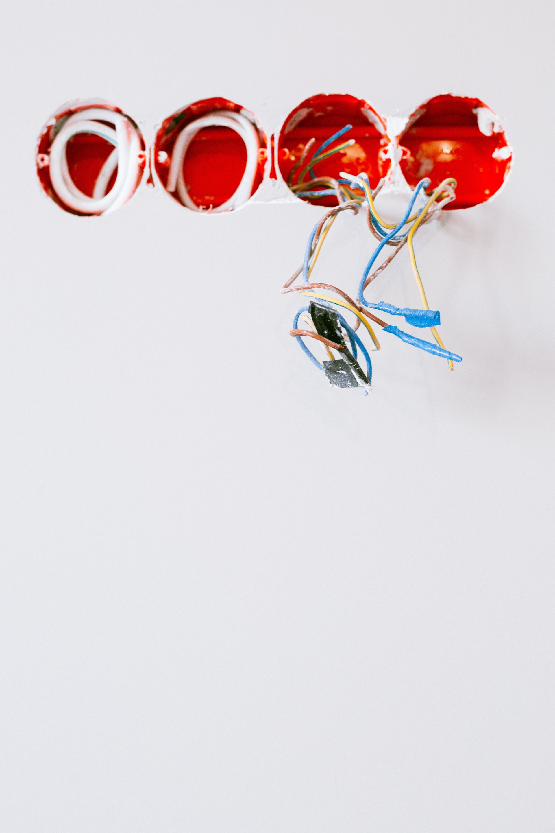 Red and silver hanging decorative discs with blue ribbons on a white background