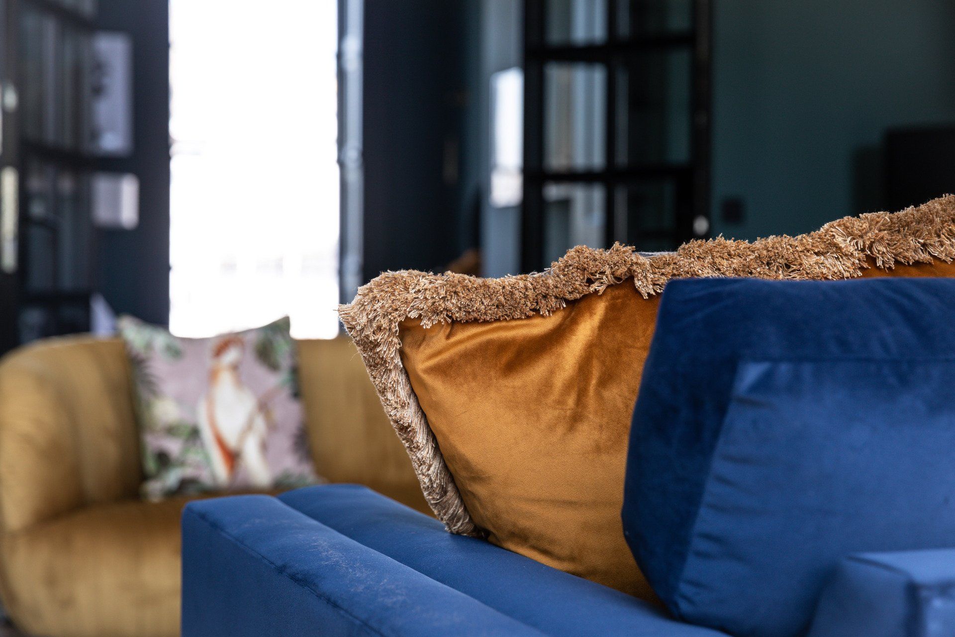A blue couch with two pillows on it in a living room.