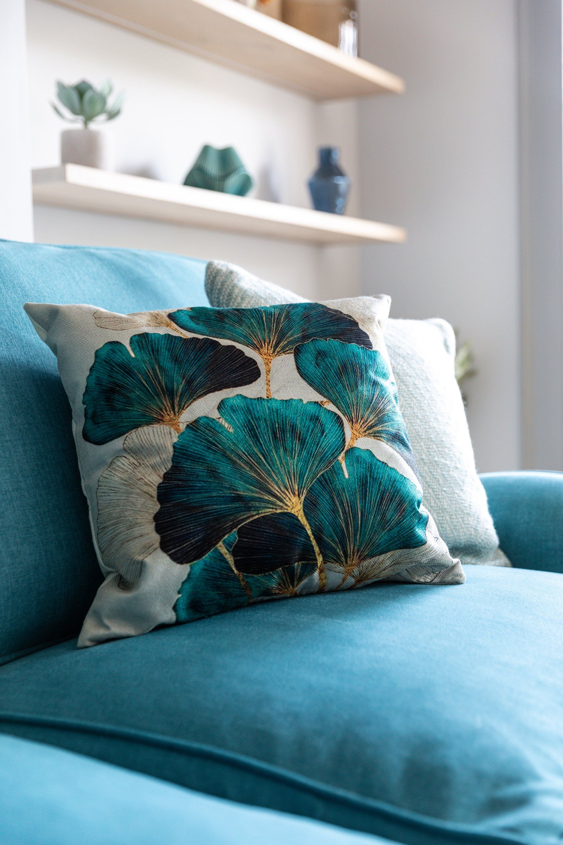 A blue couch with two pillows on it in a living room.