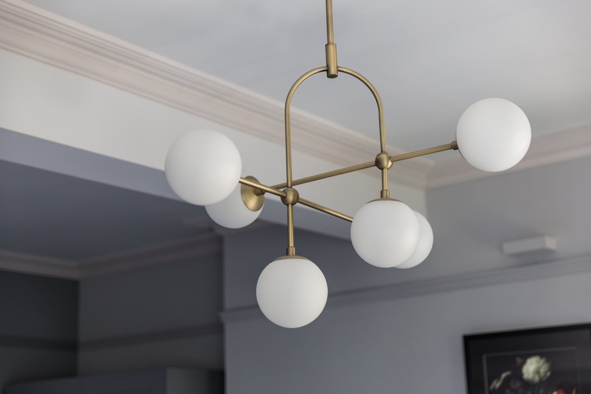 A brass chandelier with white glass balls hanging from the ceiling