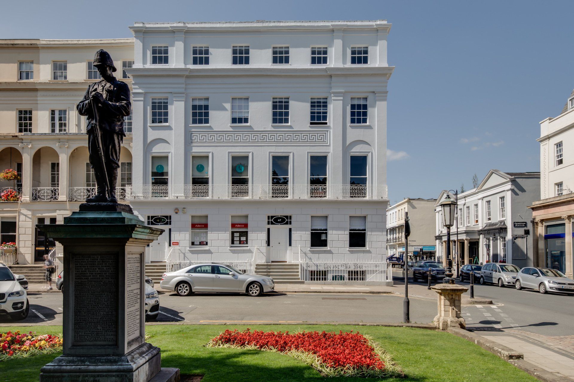A statue of a man is in front of a large white building.