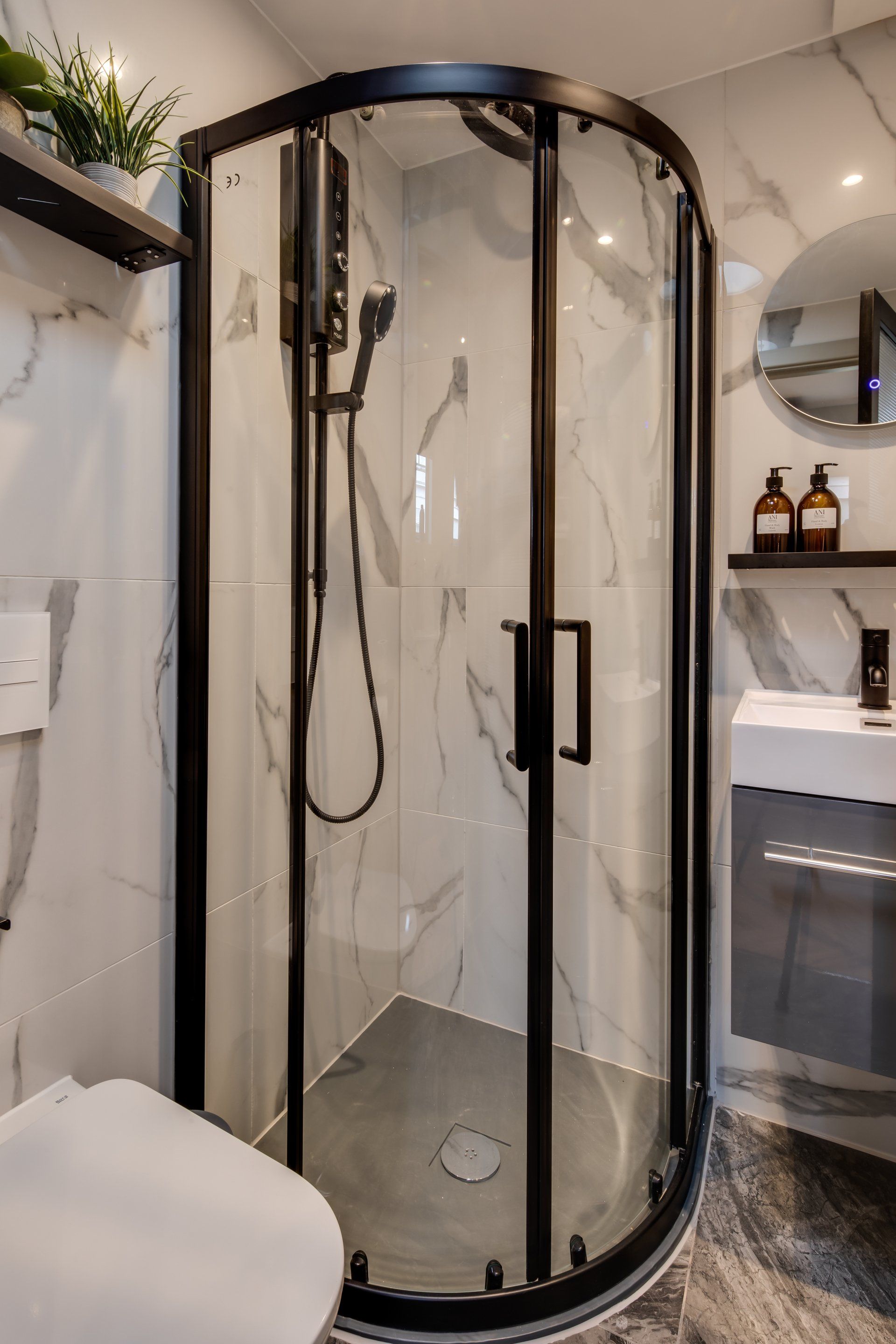 A bathroom with a toilet , sink , and shower stall.