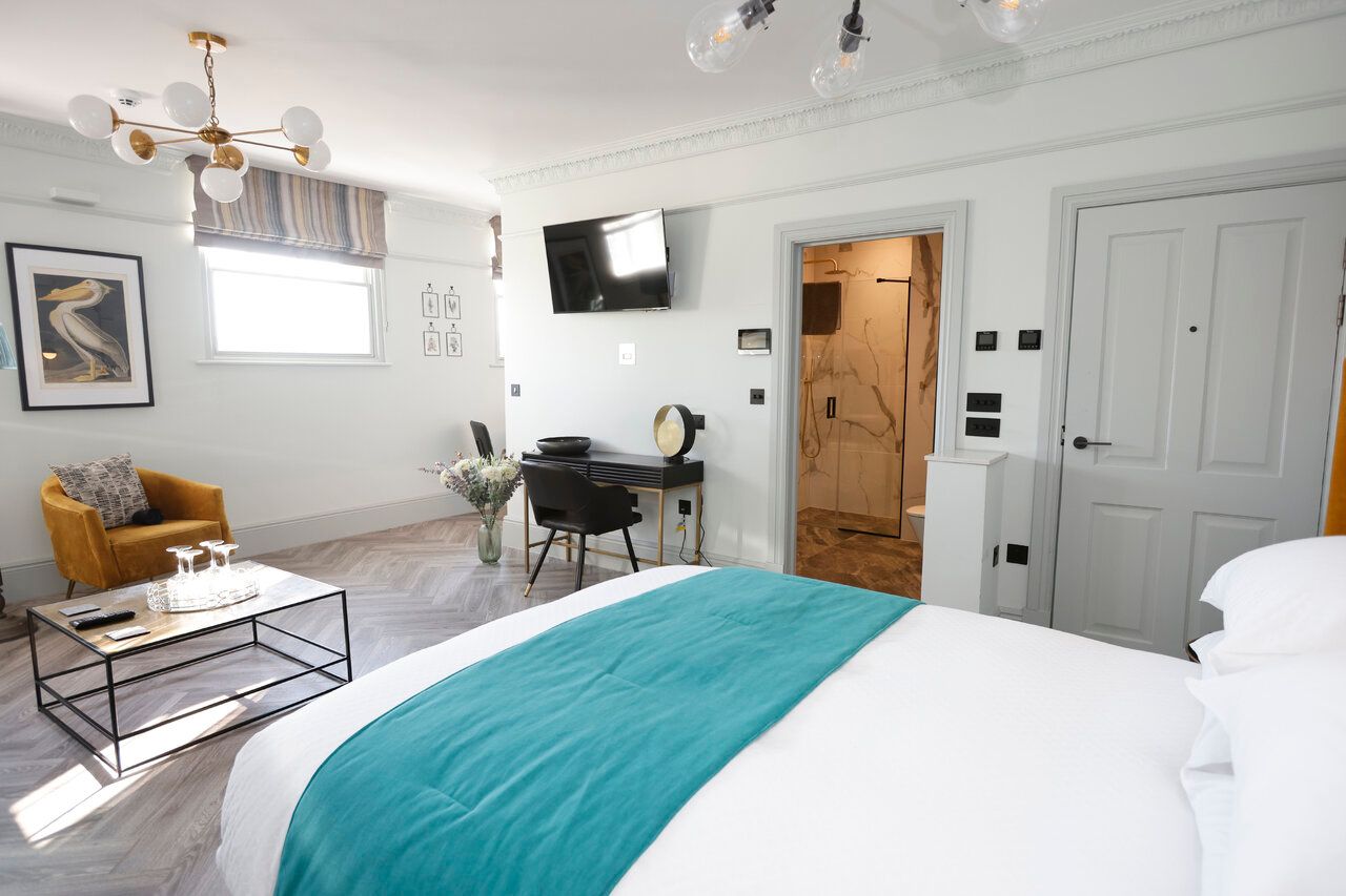 A bedroom with a bed , chair , desk and television.