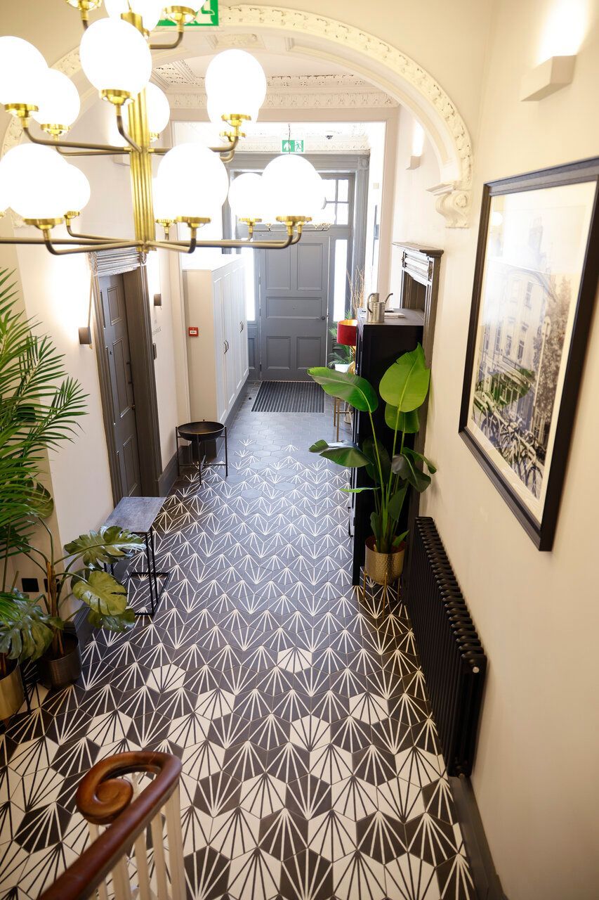 An aerial view of a hallway with a staircase and a picture on the wall.