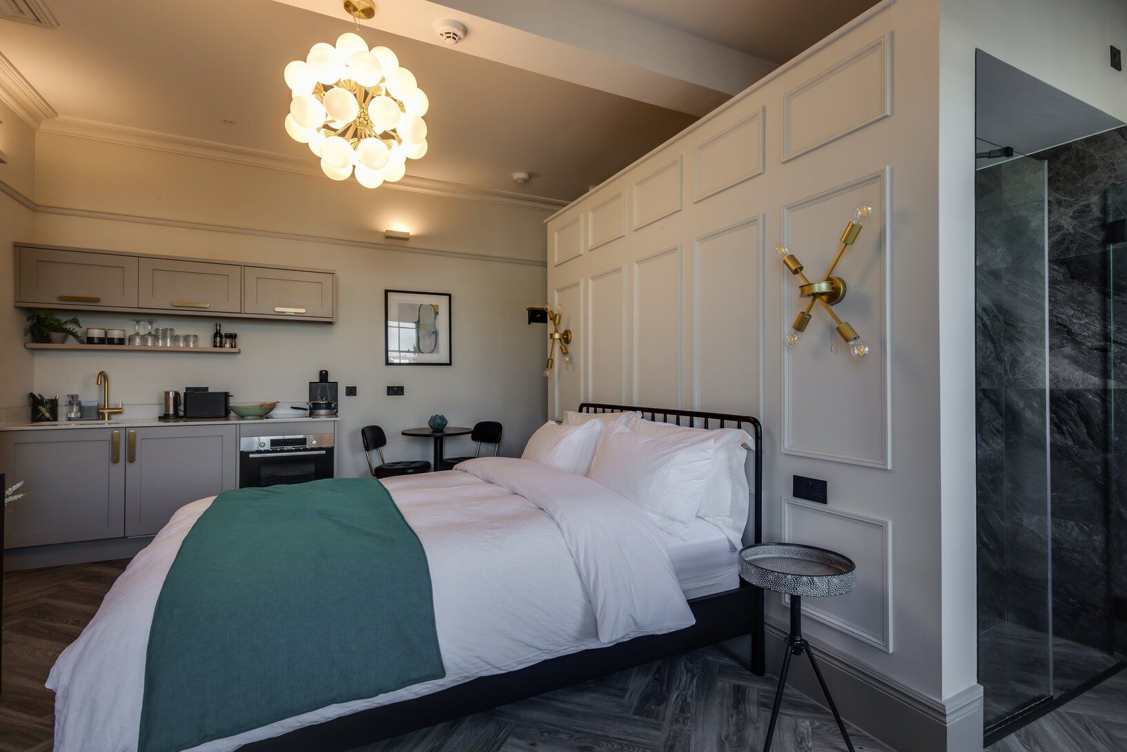 A bedroom with a large bed and a walk in shower.