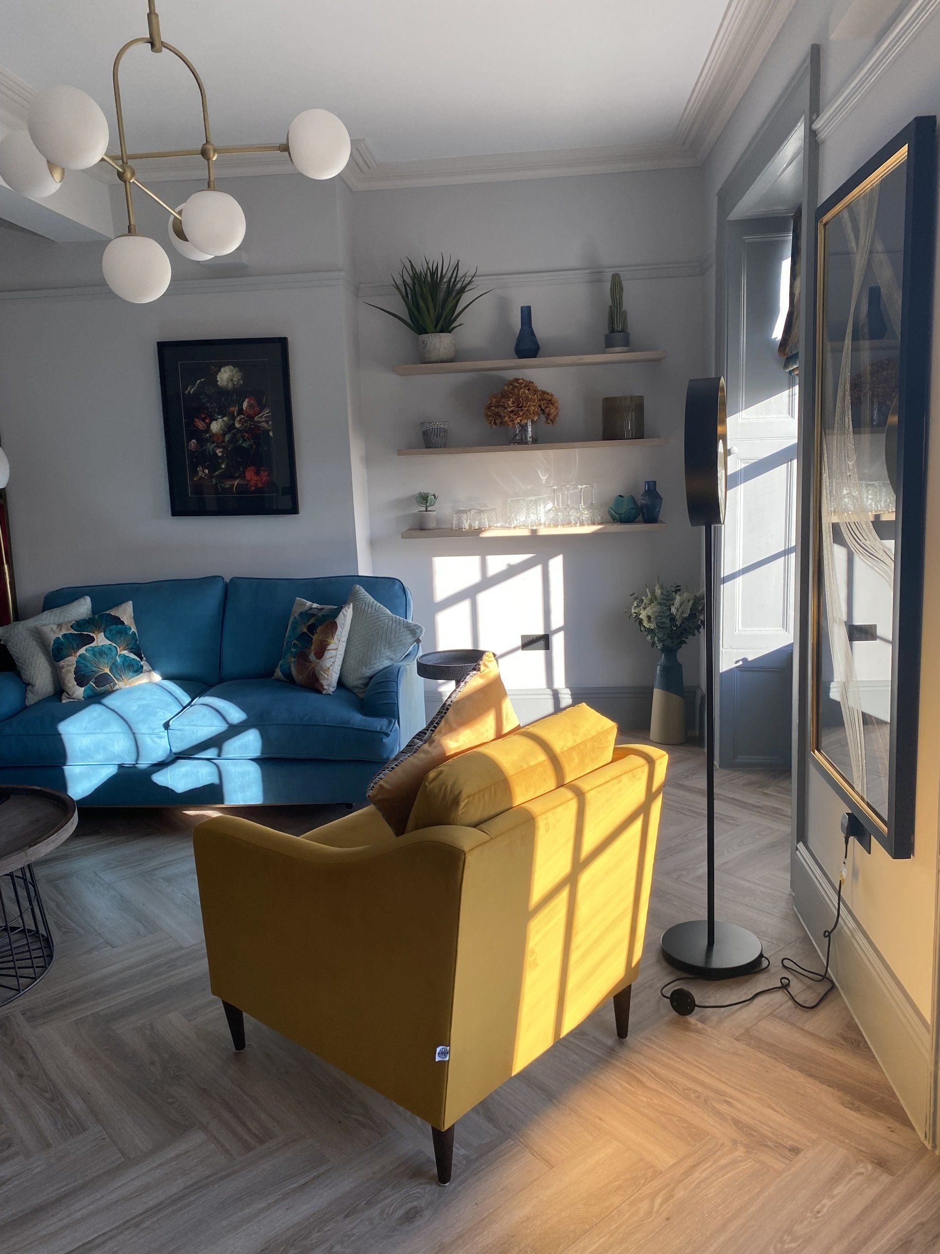 A living room with a blue couch and a yellow chair