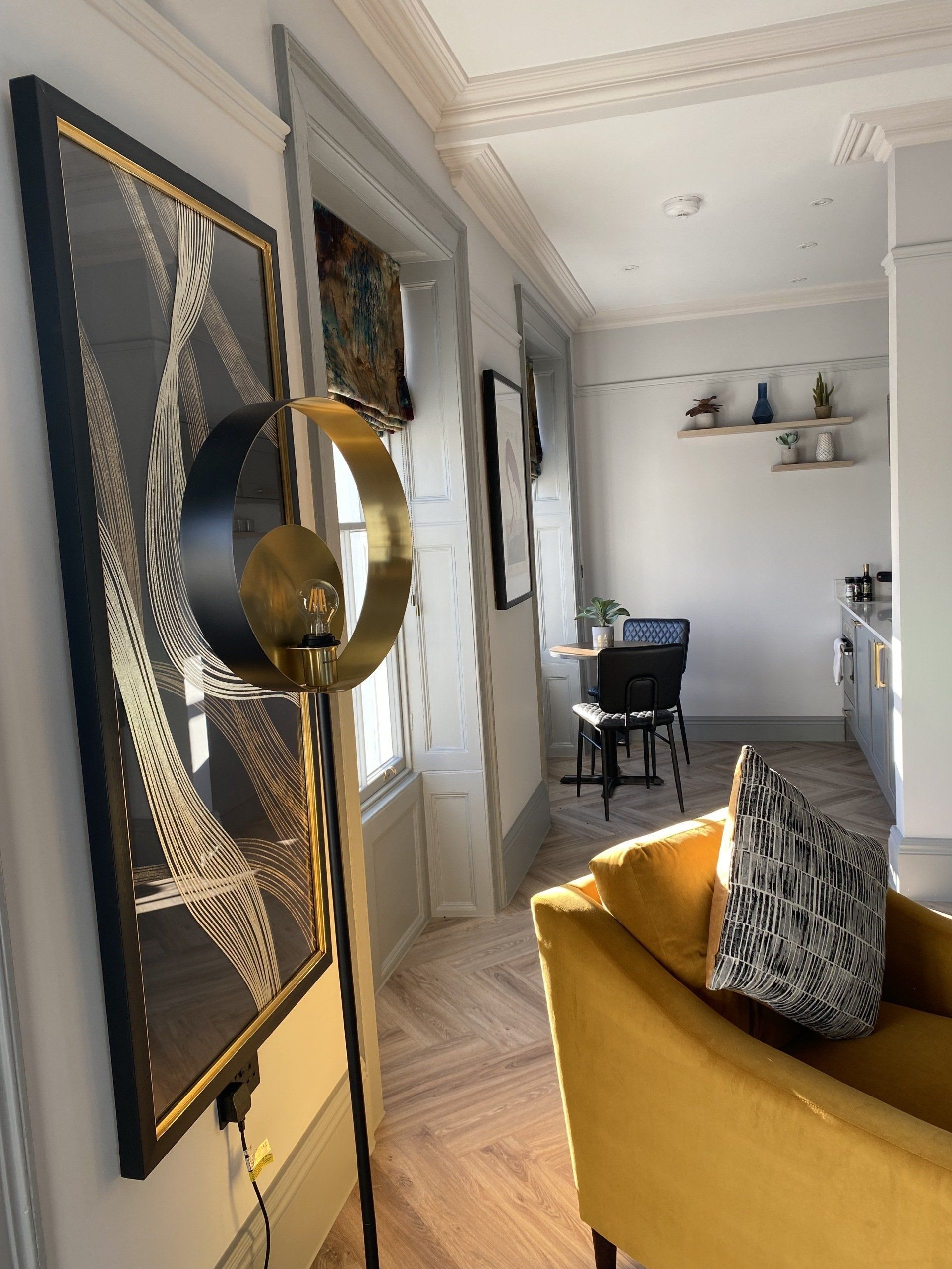 A living room with a yellow chair and a picture on the wall